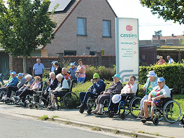 Een groep senioren in rolstoelen tijdens een buitenactiviteit bij woon- en zorgcentrum Cassiers