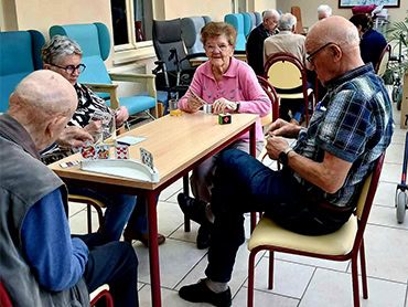 Bezoekers van het dagverzorgingscentrum genieten samen van een gezelschapsspel